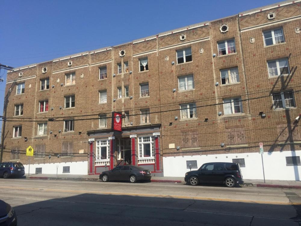 A large brick building with a red sign and white trim